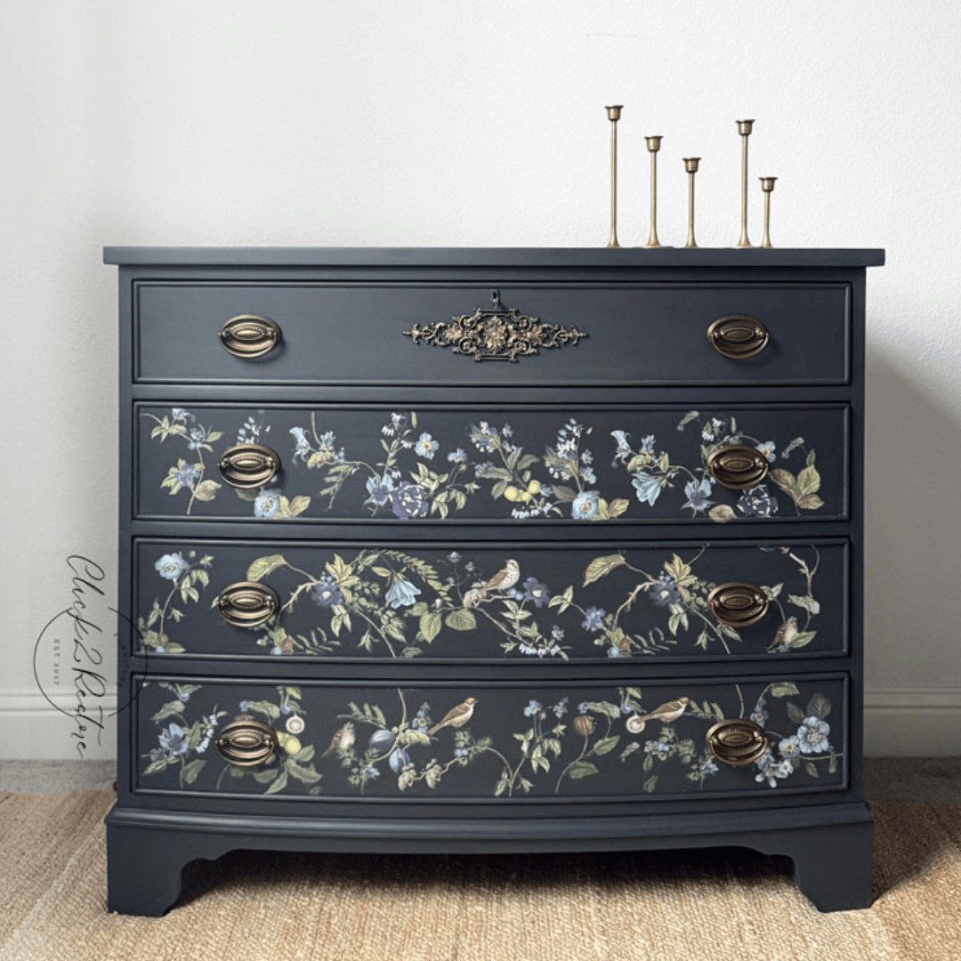 Dark gray dresser with floral patterns and gold accents on a neutral background