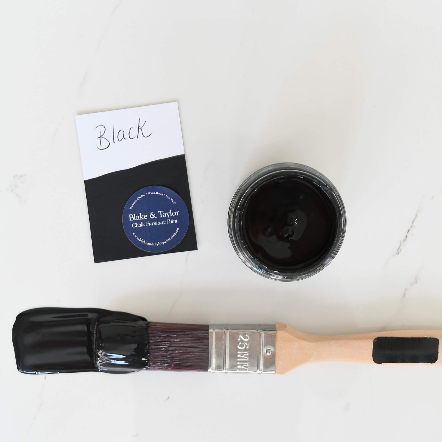 Brush dipped in a 120ml pot of Black Blake & Taylor Chalk Furniture Paint