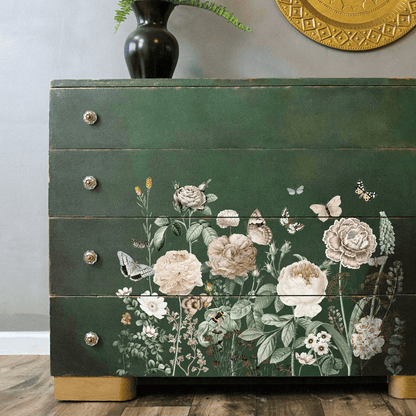 Green dresser with floral decoupage design on a wooden floor.