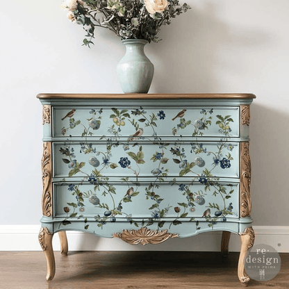 Decorative chest of drawers with floral and bird patterns on a plain background