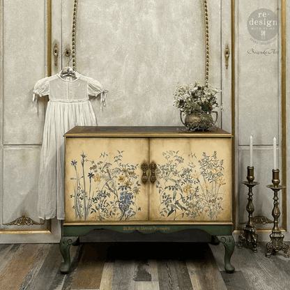 Decorative cabinet with floral design in a room with a white dress and candles.