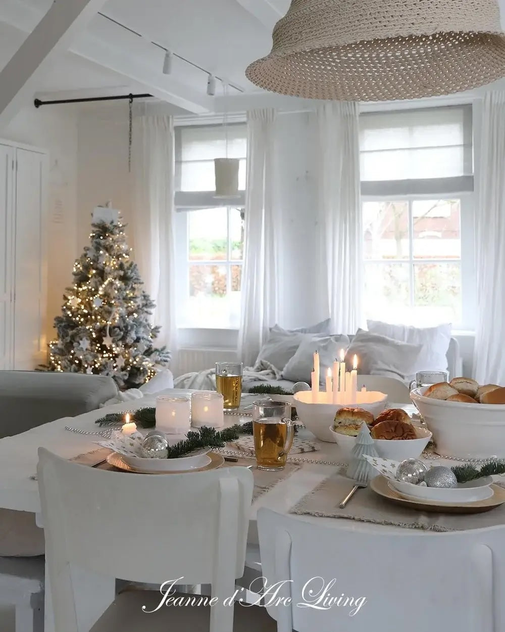 Dining room with a Christmas tree, candles, and a table set for a meal.