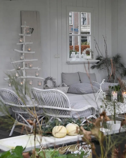 Cozy indoor setting with wicker furniture, candles, and decorative plants.