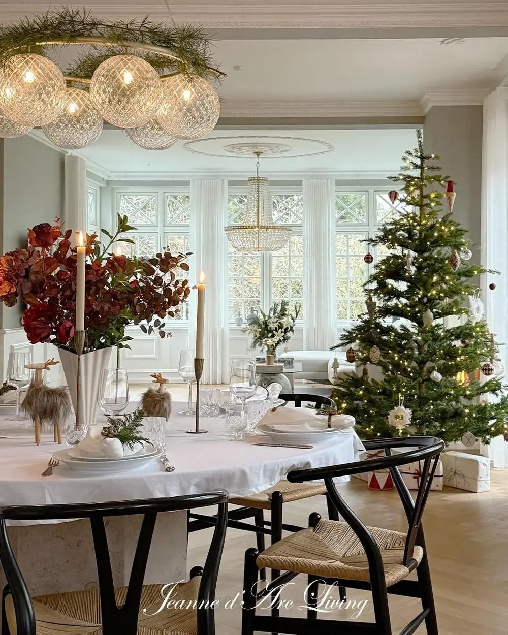 Dining room with a Christmas tree, table setting, and decorative lights.