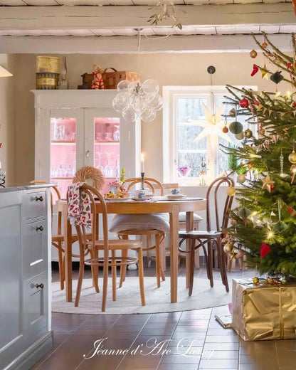 Dining room with a Christmas tree and decorated table, featuring a chandelier and gift-wrapped presents.