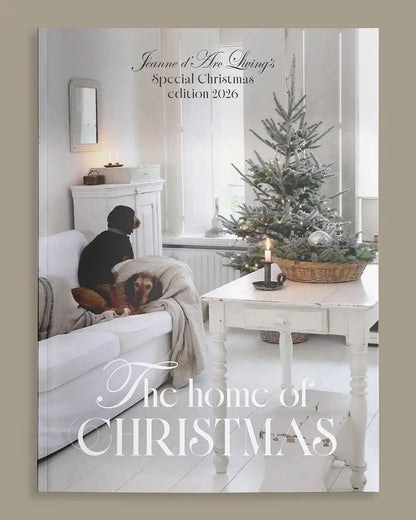 Magazine cover featuring a cozy living room with a Christmas tree and text about a special Christmas edition.