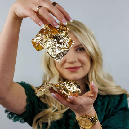Female holding sheets of gold leaf in her hands