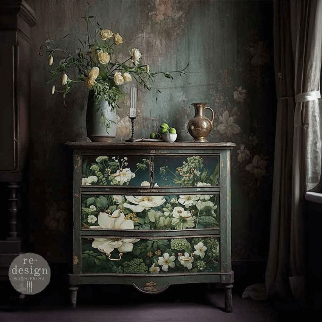 Decorative chest of drawers with floral decoupage in a dark room.
