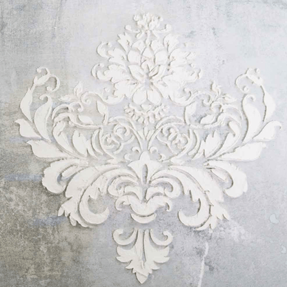 Decorative white stencil with intricate patterns on a textured gray background
