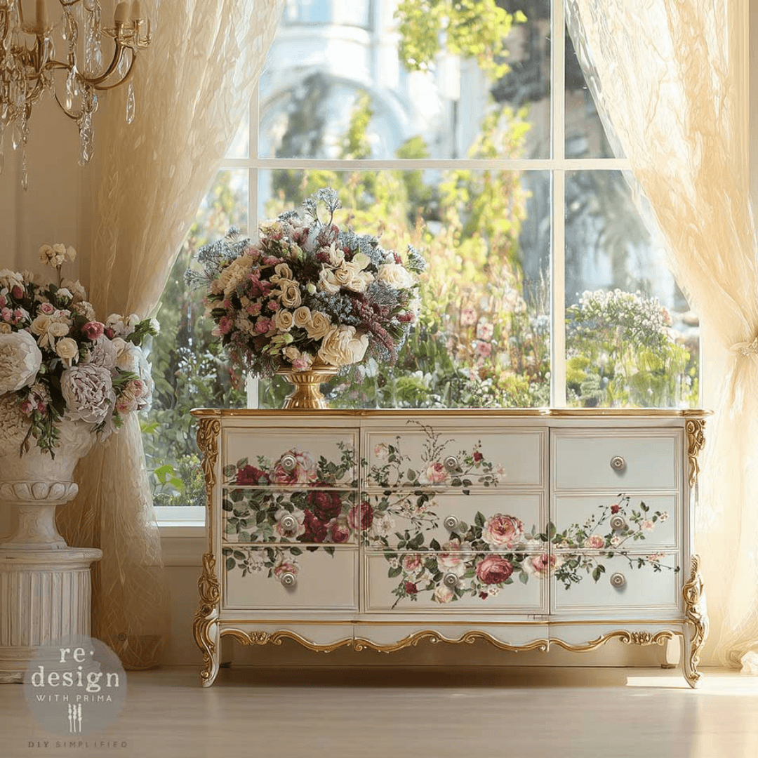 Decorative chest of drawers with floral patterns in a room with large windows and floral arrangements.