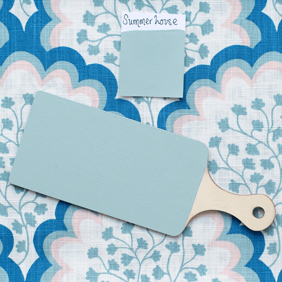 Paint swatch and paintbrush on a floral patterned surface with 'Summer house' text.