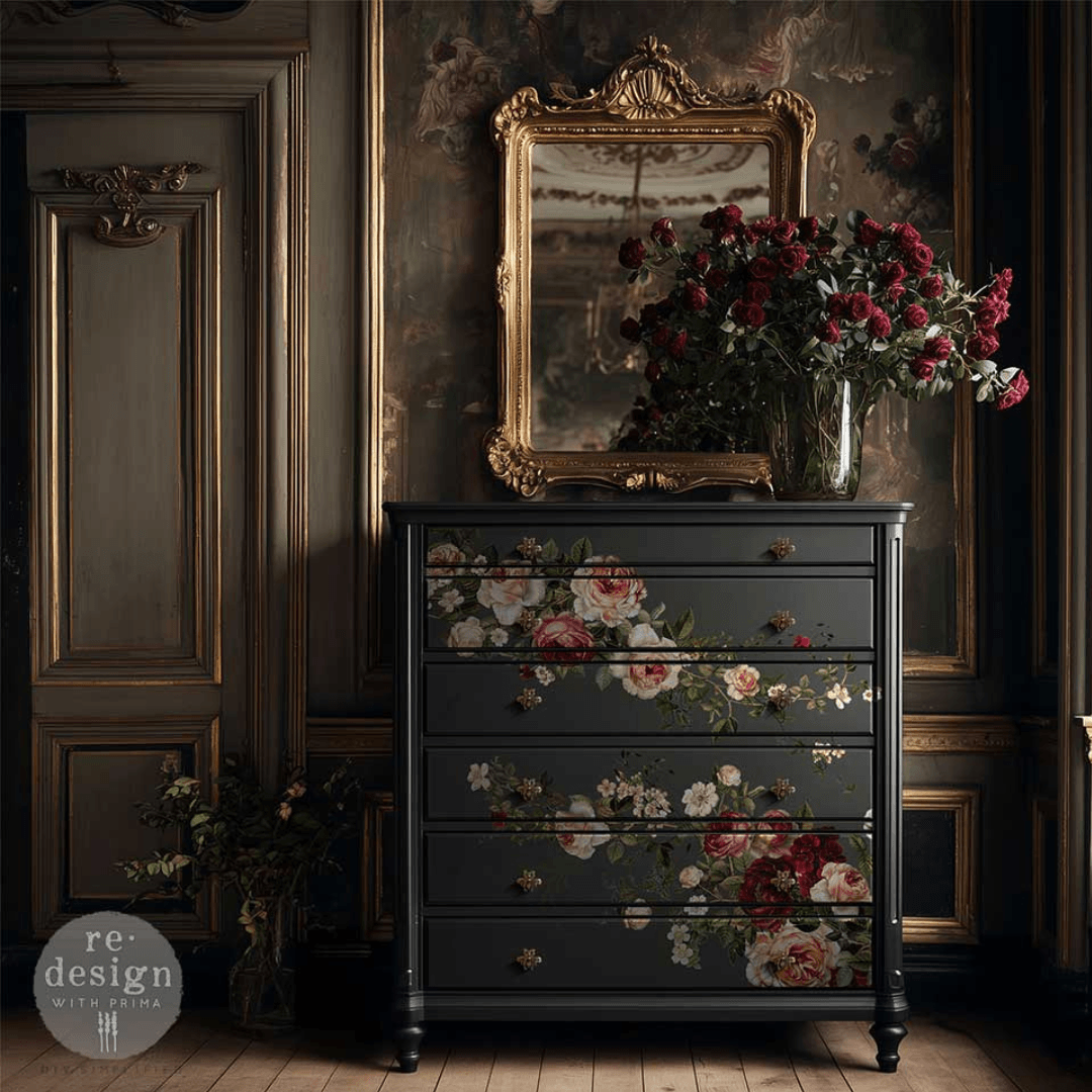 Dark dresser with floral design in a room with a mirror and flowers.