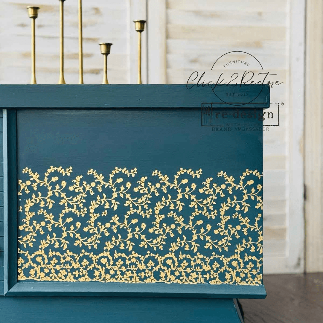 Teal decorative box with gold floral patterns against a neutral background