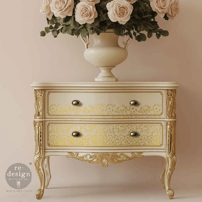 Decorative chest of drawers with gold accents and a vase of flowers on a beige background