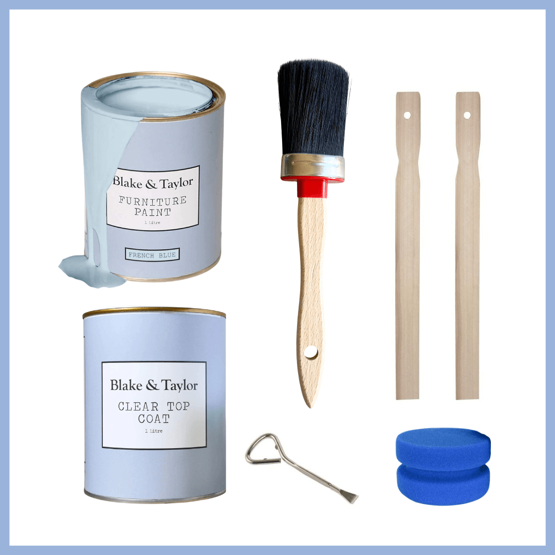 A furniture paint kit with two cans of Blake & Taylor furniture paint, a paint brush, two wooden sticks, a metal scraper, and two blue sanding discs, arranged on a white background with a blue border.