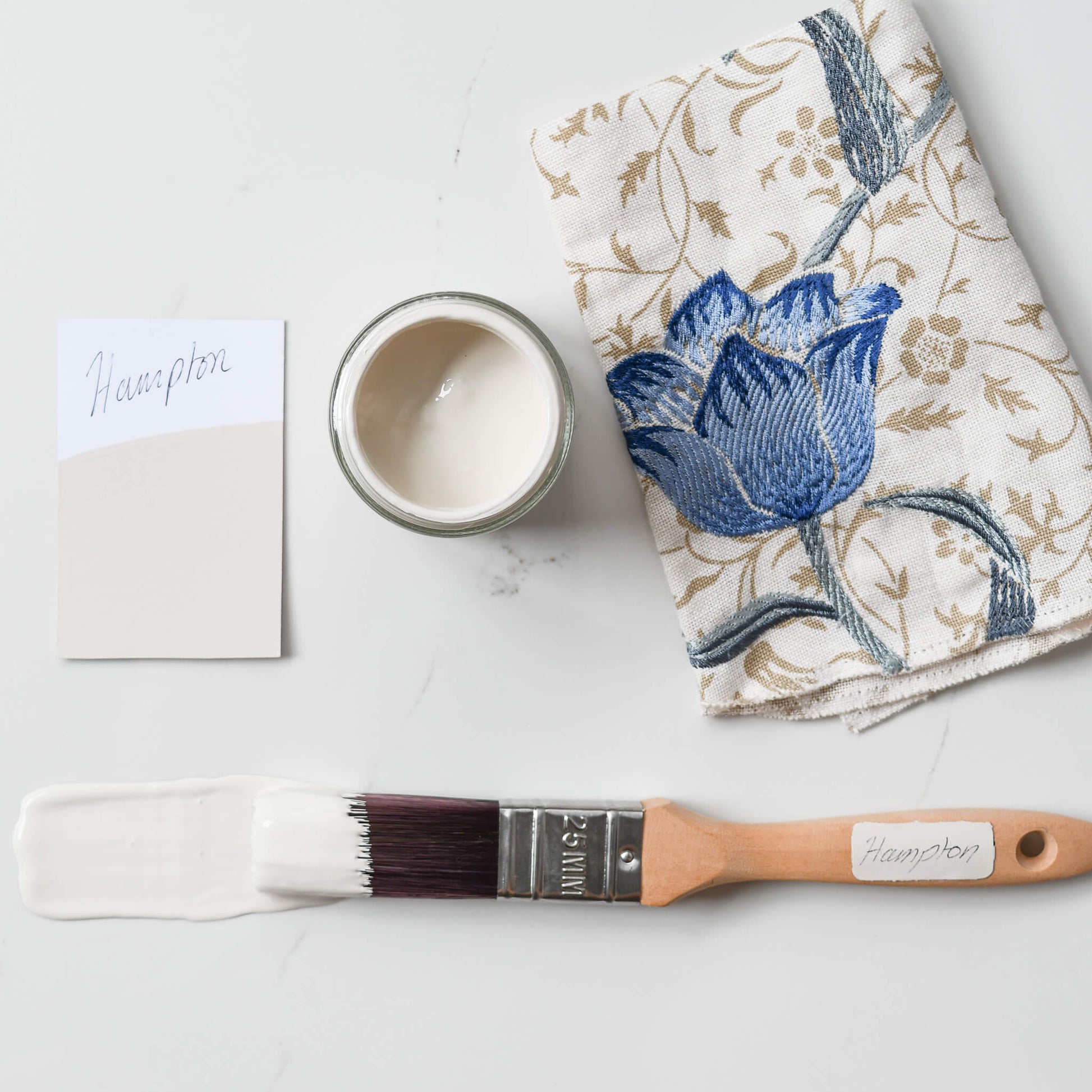 Fabric mood board with paintbrush dipped in 120ml pot of Blake & Taylor Hampton Chalk Furniture Paint