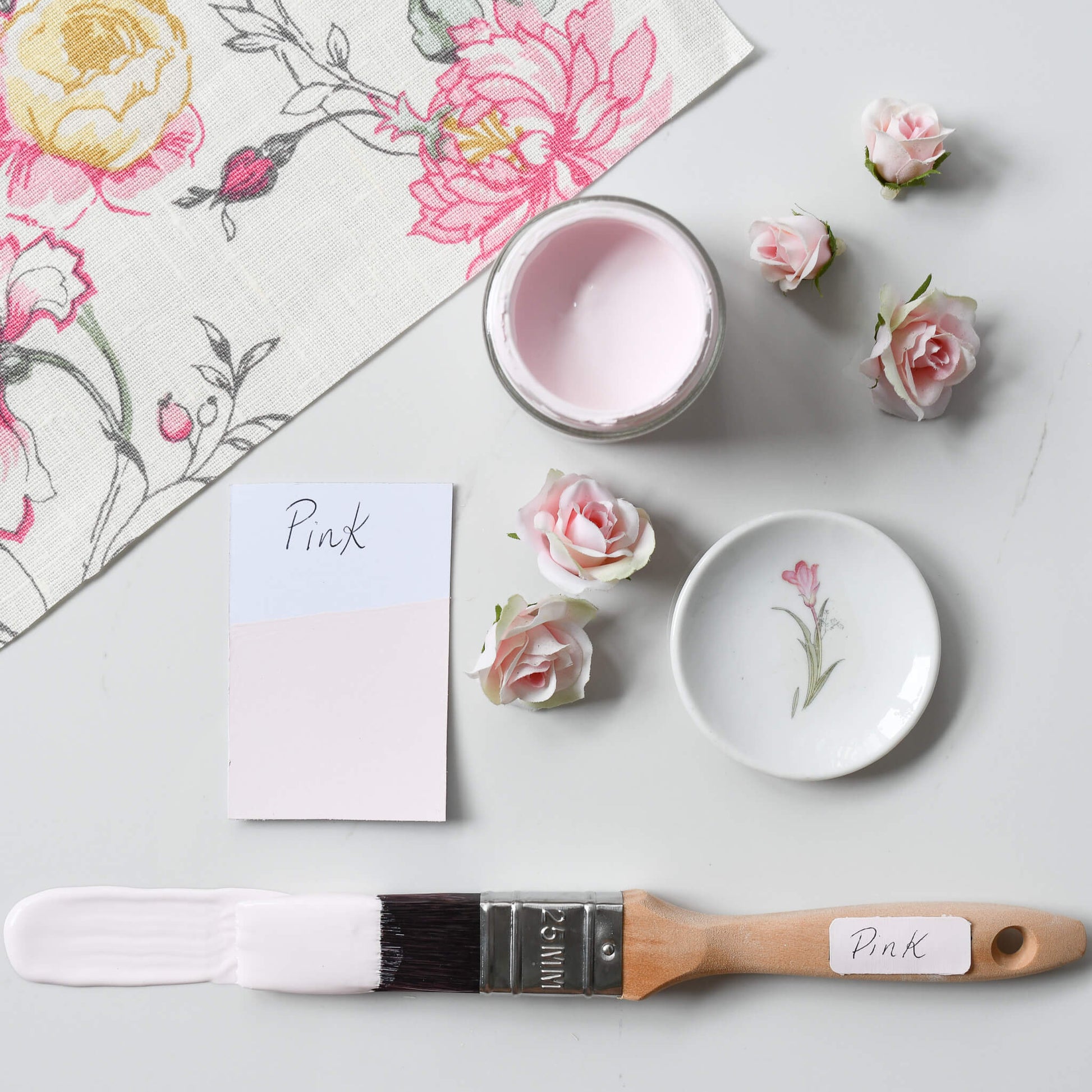 Fabric mood board with paint brush dipped in 120ml pot of Blake & Taylor Pink  Chalk Furniture Paint